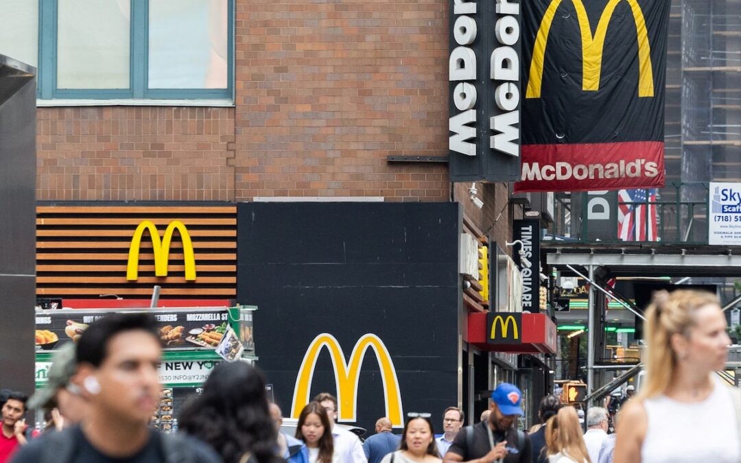 Peatones pasando frente a un local de McDonald's en una calle urbana